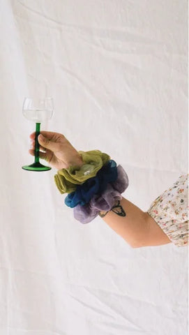 holding a glass hand with three naturally dyed scrunchies